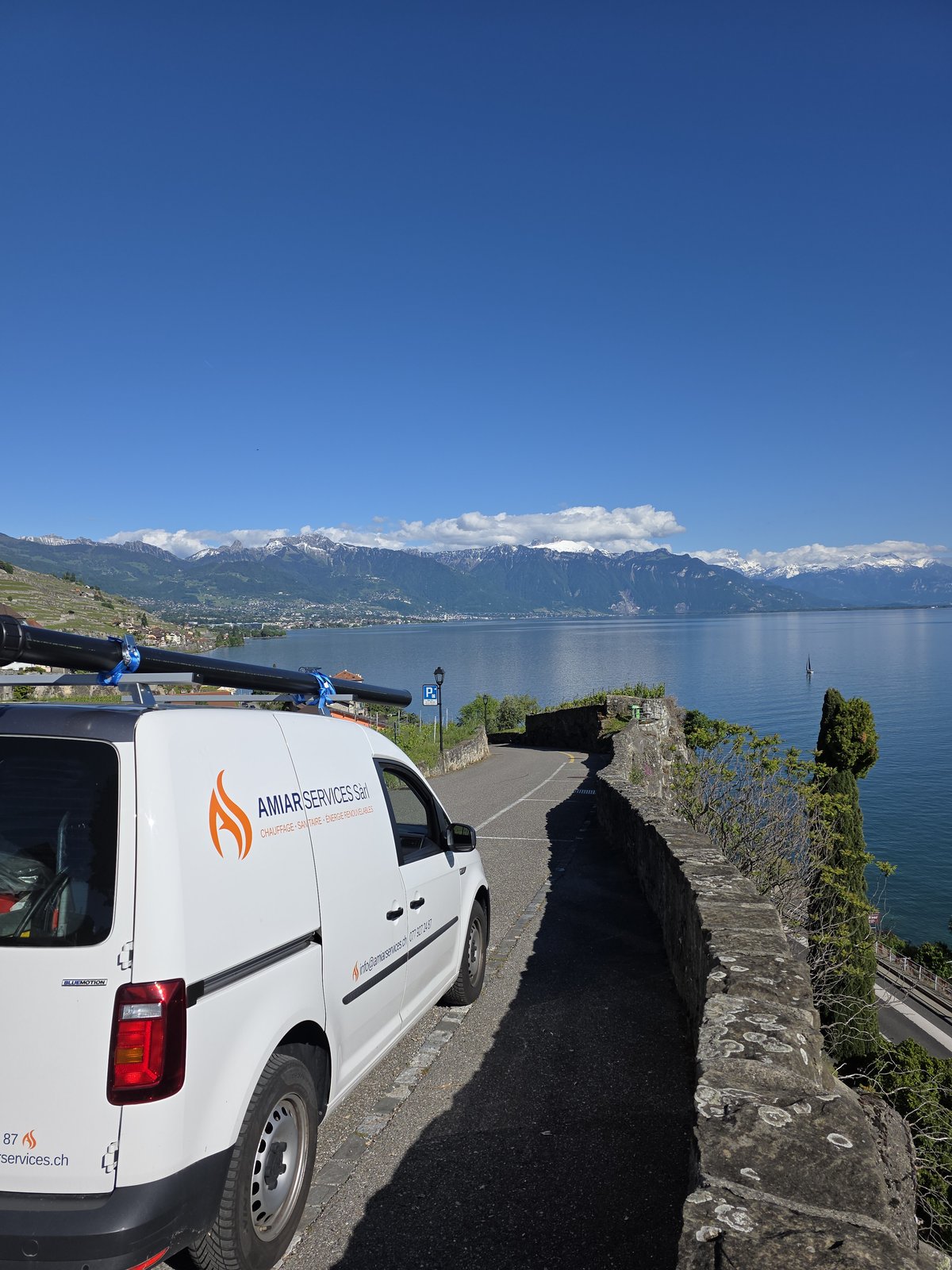 Véhicule AMIAR Services Sàrl sur la route du Lavaux — vue panoramique sur le Léman et les Préalpes valaisannes